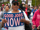 Black women holds "Good Jobs Now!" sign at a march
