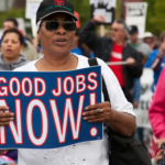 Black women holds "Good Jobs Now!" sign at a march