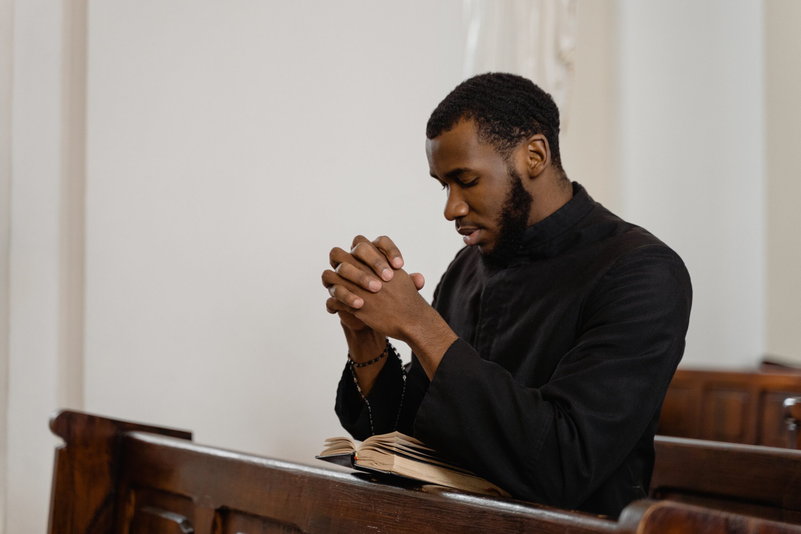 Young African American man praying in a church