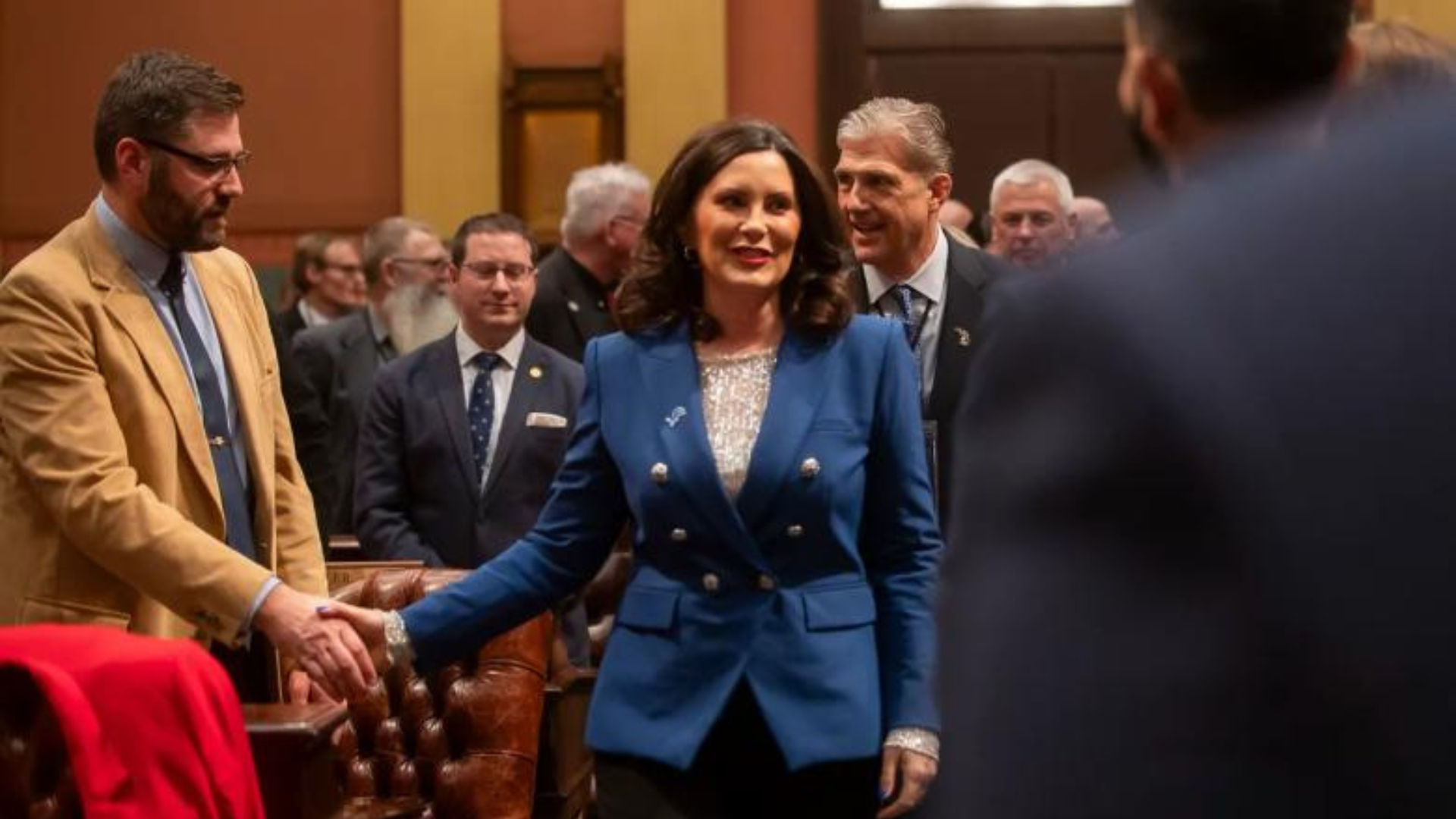 Michigan Gov. Gretchen Whitmer shakes hands with legislators at her sixth State of the State address in the Michigan House Chambers.